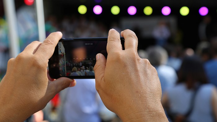 Person tar bilde med sin mobil på konsert